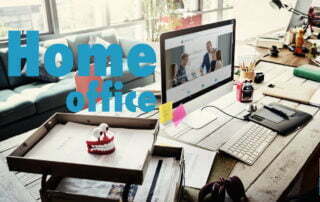Bild von einem warm, gemütlichen Büro mit Holztischen und Bürozubehör und einem Schriftzug in blau Homeoffice