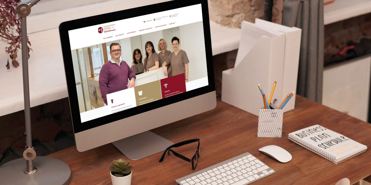 Mockup eines Schreibtisches mit Utensilien und einem Desktop, welcher eine Webseite zeigt